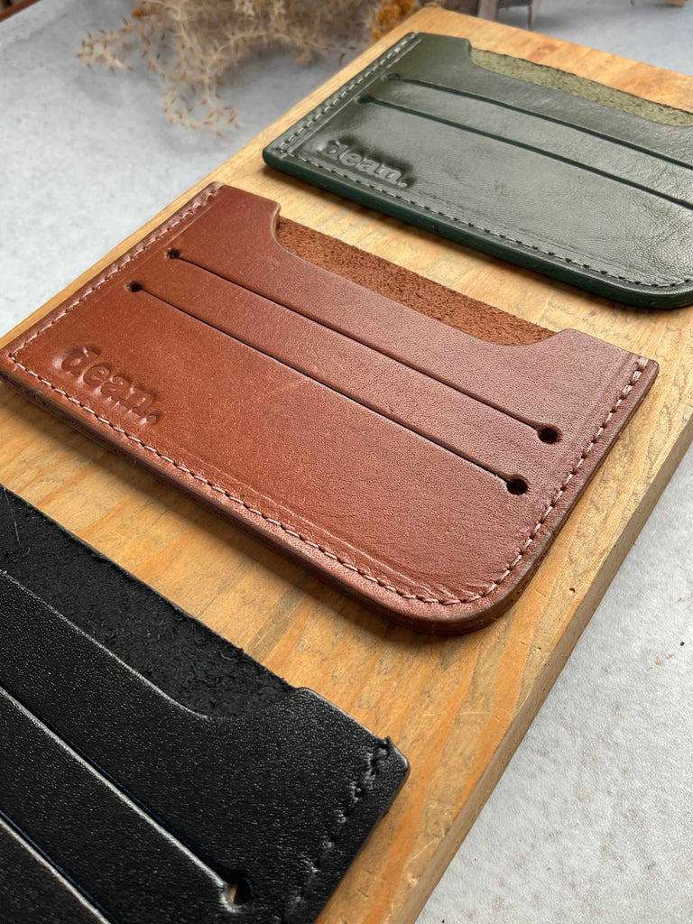 Handmade leather card holders in hunter green, cognac, and black