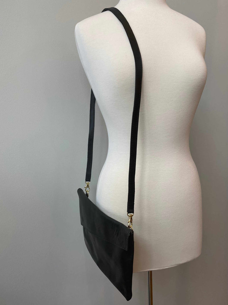 Black crossbody and clutch bag with removable strap on mannequin