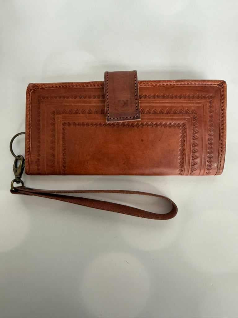 Handmade brown leather wallet with wrist strap on a white background