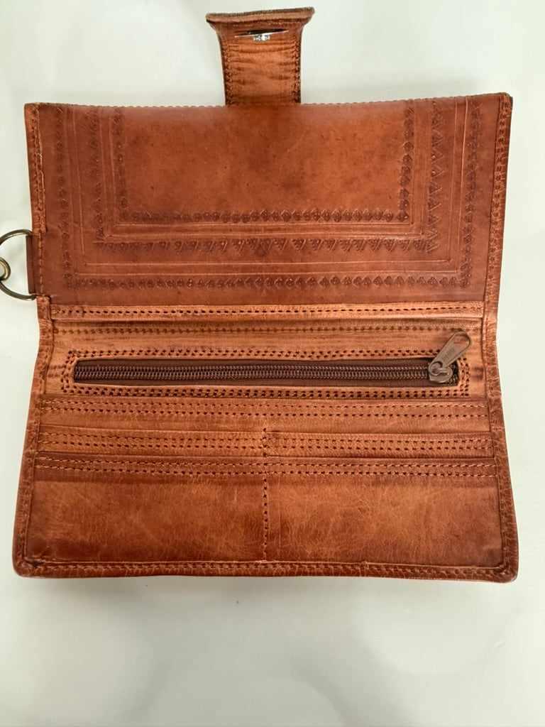 Brown leather wallet with intricate designs on a white background