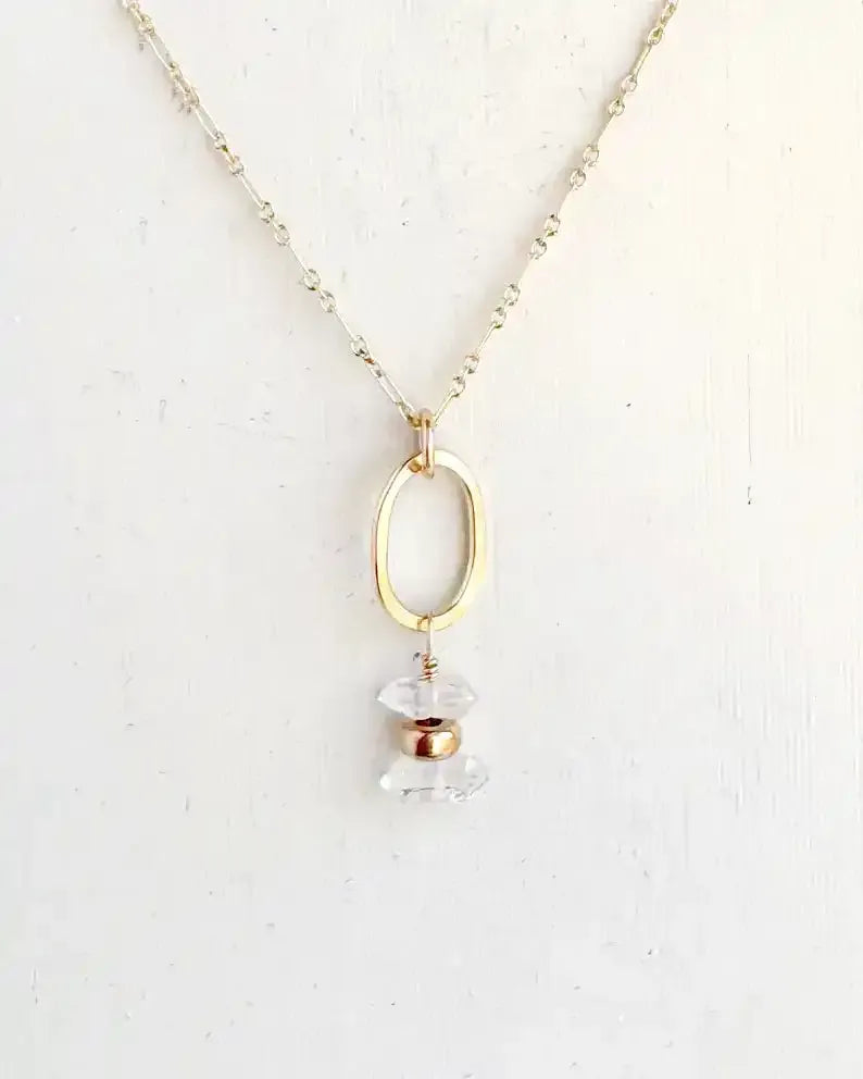 Necklace with a gold pendant and clear crystal on a white background