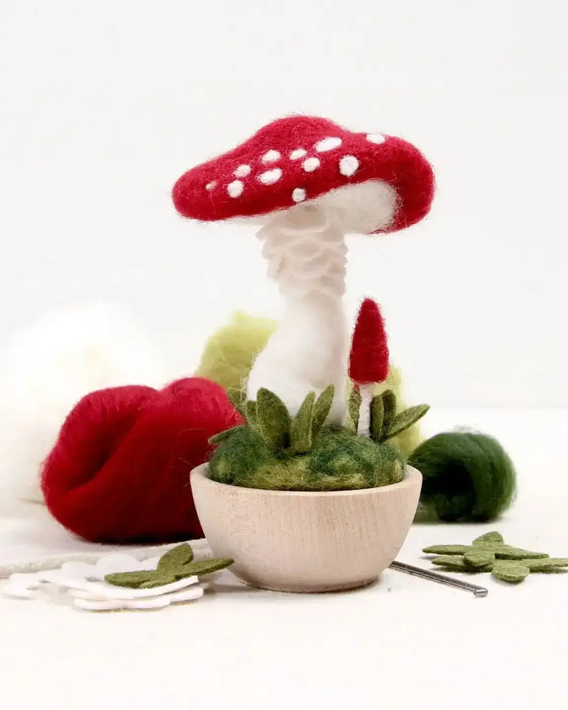 Felted mushroom kitwith red cap and white stem on a white background