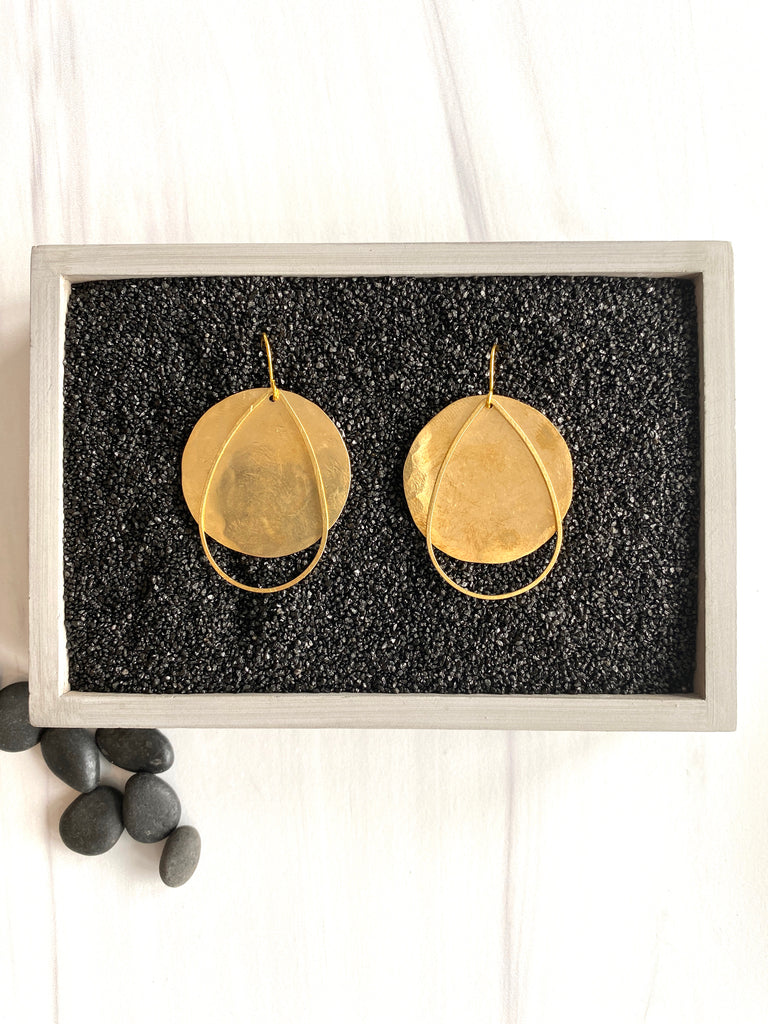 Brass full moon earrings on display