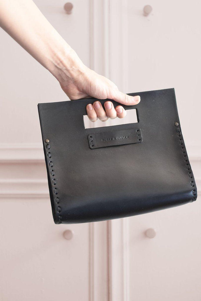 Woman holding Everyday leather clutch in black