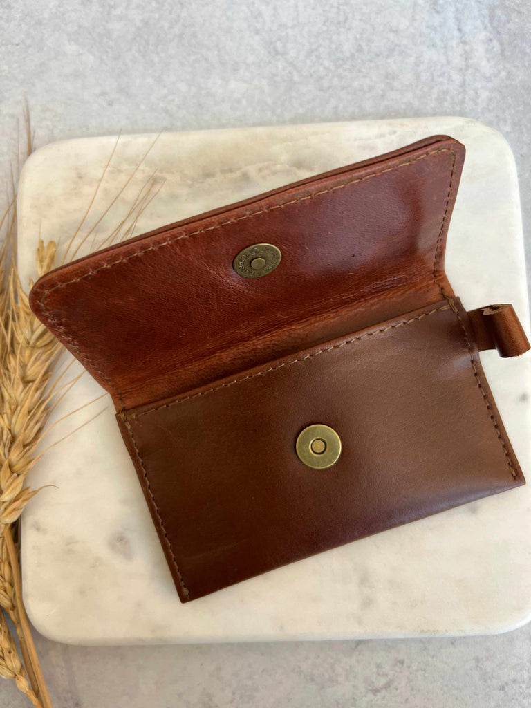 Snap closure on leather card carrier in chestnut brown
