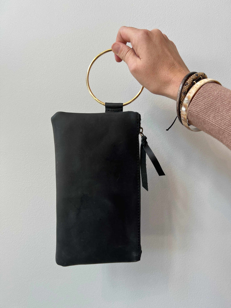 Woman holding Able Fozi wristlet in black