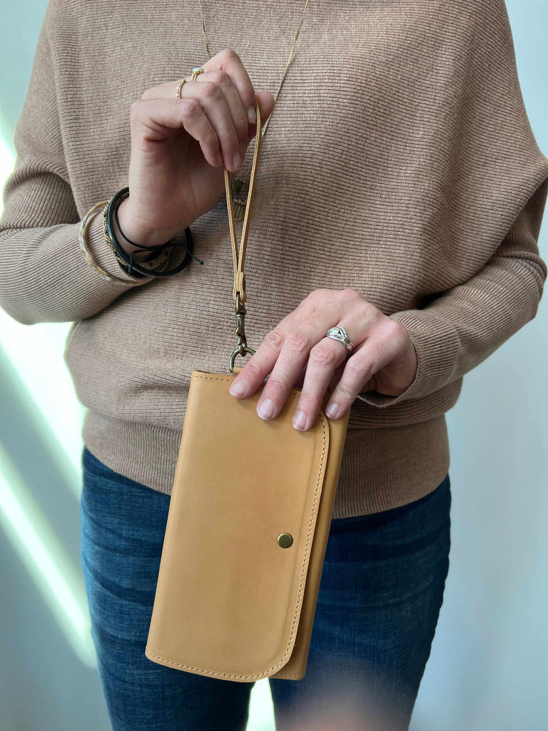 Woman holding Mare leather phone wallet in cognac