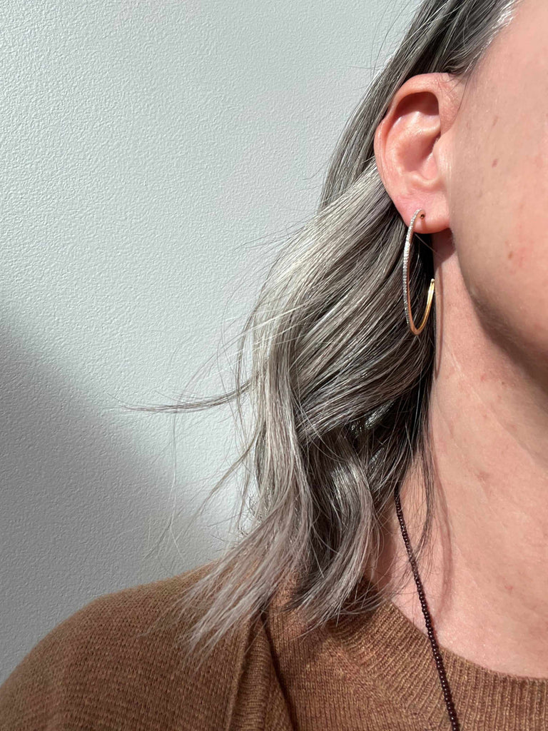 Woman wearing Ella Stein large diamond hoops in 14k gold plated sterling