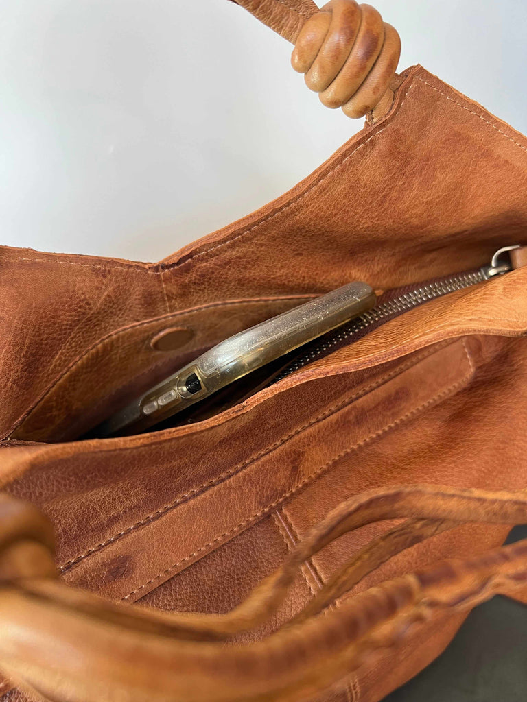Phone in pocket of Latico leather Nash crossbody bag