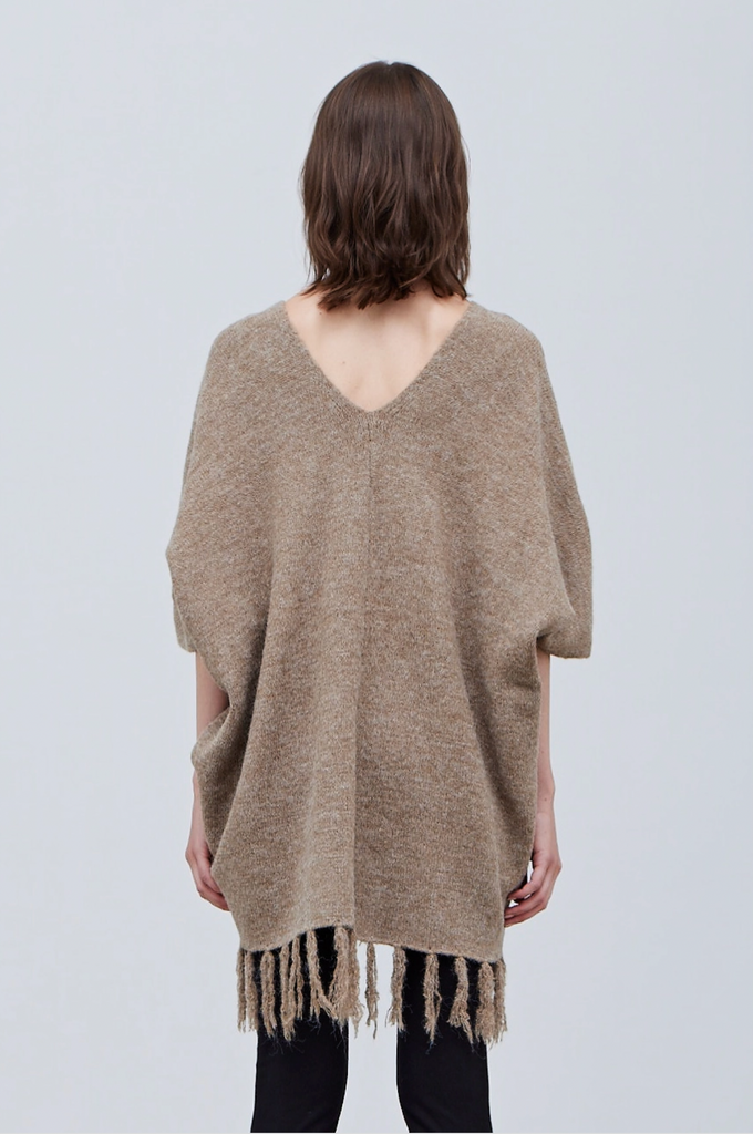 Back of Fringe Hem Knit Poncho on model