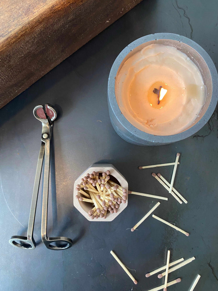 Match Stick Holder with Striker beside lit candle and wick trimmer