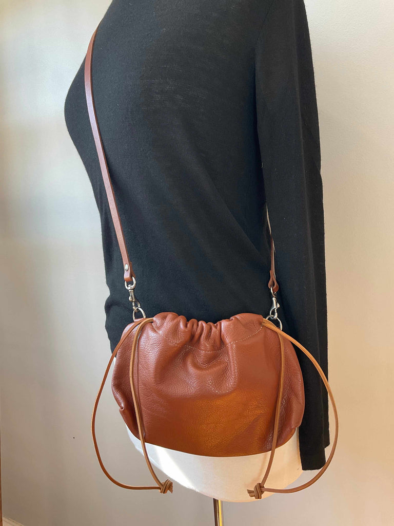 Cognac leather crossbody drawstring clutch with removable strap